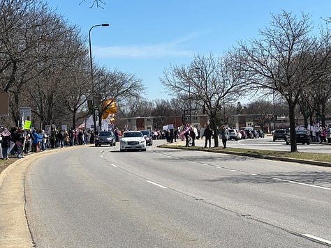 Protesters and dogs with signs at an outdoor rally