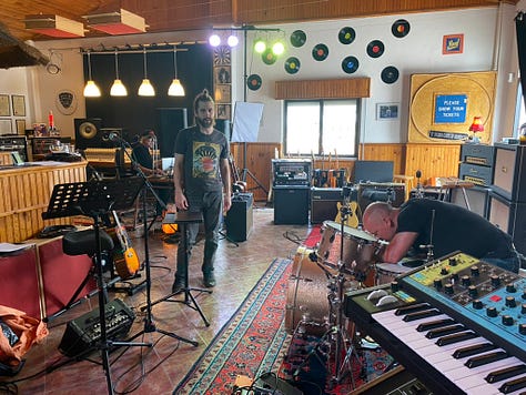 Musical equipment and people inside a recording studio
