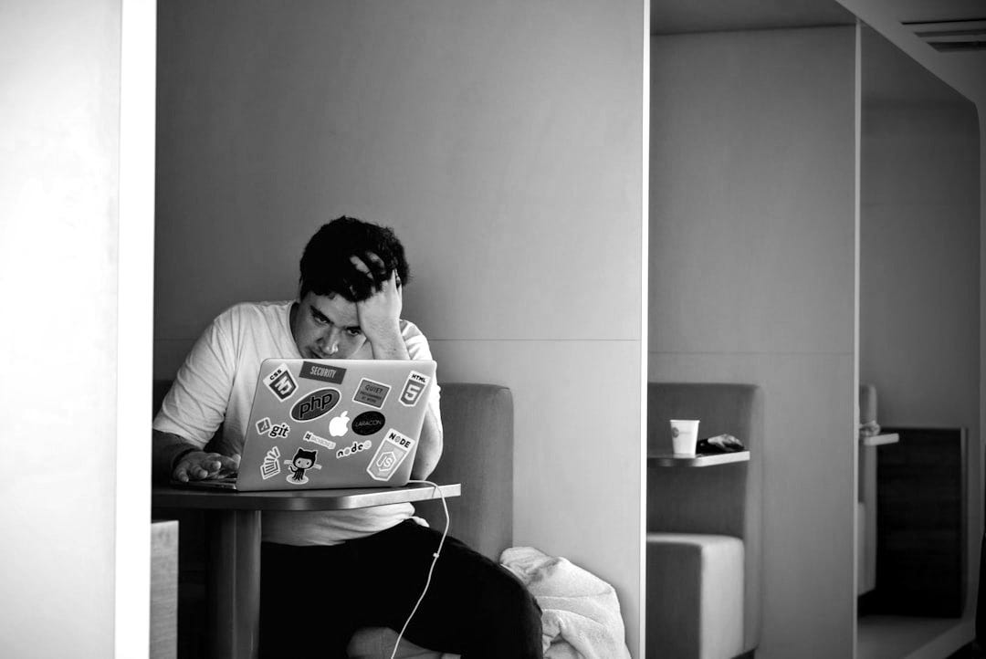 man wearing white top using MacBook