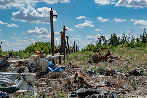 Traces of devastation and resilience in Andriivka. Amidst the shattered remains of buildings, rusted debris, and skeletal trees stripped bare by war, nature begins its quiet defiance — stubborn green shoots rising through the scars of conflict. (VX Photo/ Vudi Xhymshiti)