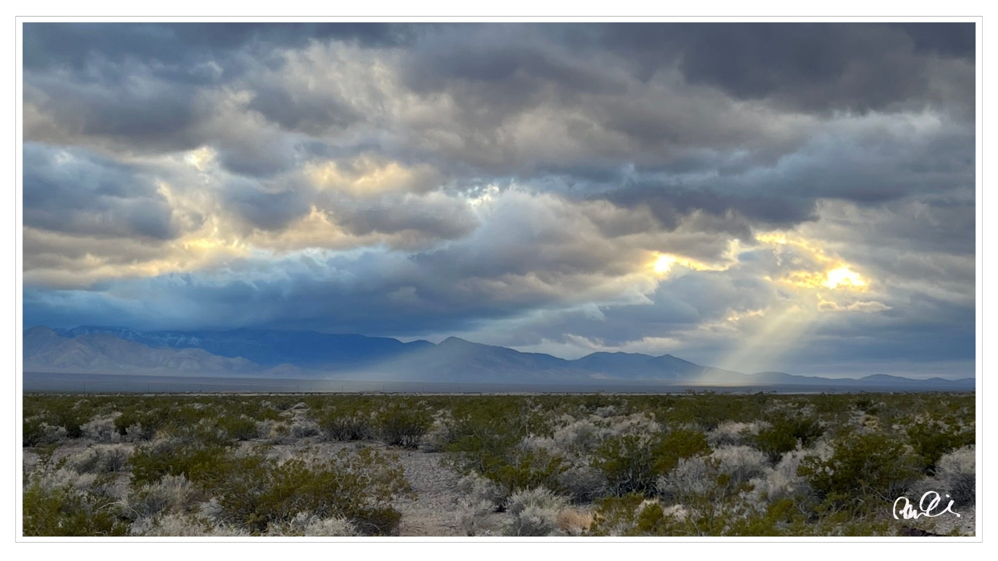 Sun breaking through sunset clouds, Mohave Desert, NV
