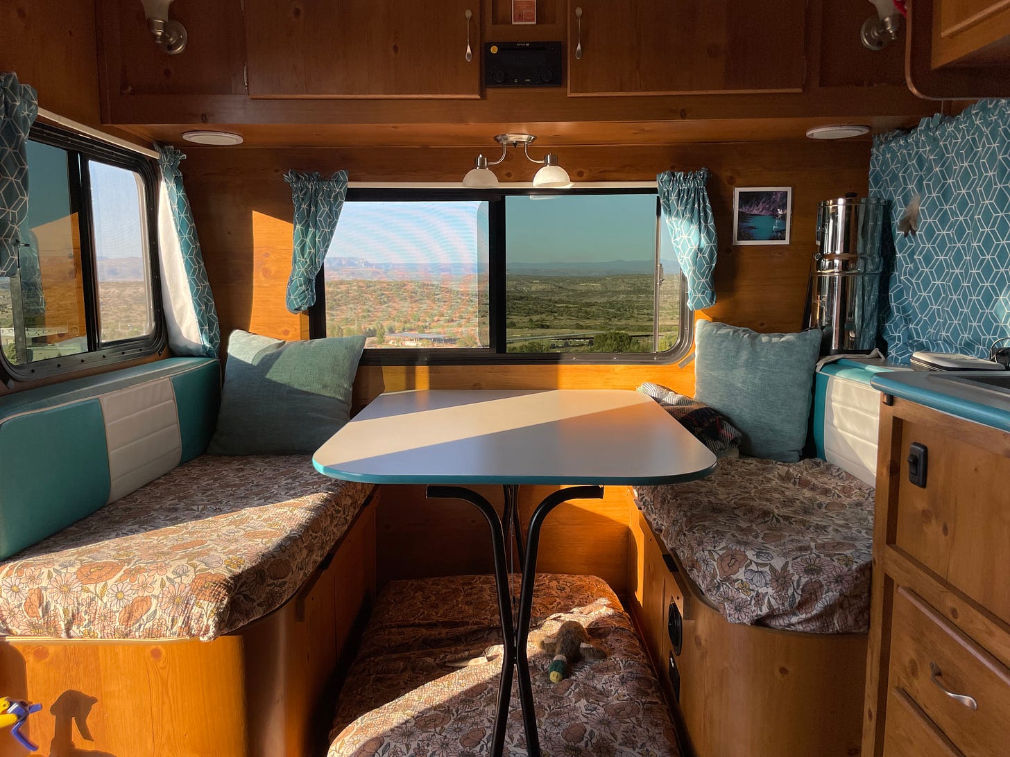 a dinette in an rv with the sun's golden rays shining in