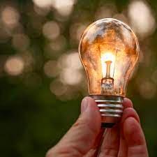 A hand holding a light bulb