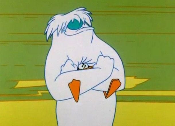 A still from a Looney Tunes cartoon, in which the abominable snowman is crushing Daffy Duck