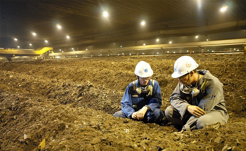 Workers examining material inside Edmonton’s composting hall Workers examining material inside Edmonton’s composting hall