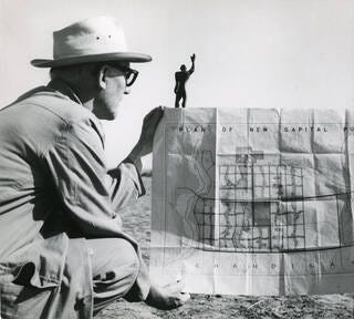 Photograph of Le Corbusier in Chandigarh with the plan of the city 