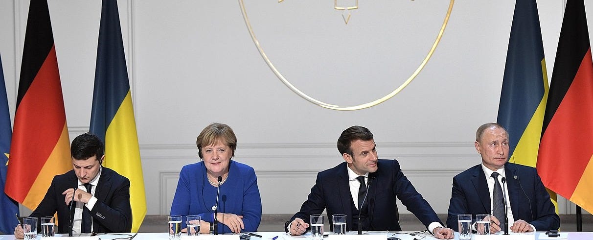 Photo: 2019 Paris Normandy Format summit (Zelenskyy, Putin, Macron, Merkel at table). Wikimedia Commons user Пресс-служба Президента Российской Федерации / CC BY-SA 4.0 https://commons.wikimedia.org/wiki/File:Zelensky,_Merkel,_Macron,_Putin,_(2019-12-10)_03.jpg Photo: 2019 Paris Normandy Format summit (Zelenskyy, Putin, Macron, Merkel at table). Wikimedia Commons user Пресс-служба Президента Российской Федерации / CC BY-SA 4.0 https://commons.wikimedia.org/wiki/File:Zelensky,_Merkel,_Macron,_Putin,_(2019-12-10)_03.jpg
