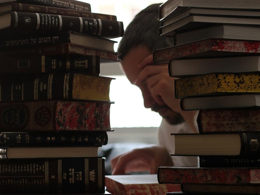 a stack of books sitting on top of a wooden table