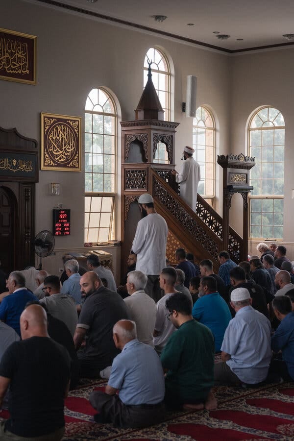 Men sitting on the floor inside a mosque during a service. Men sitting on the floor inside a mosque during a service.