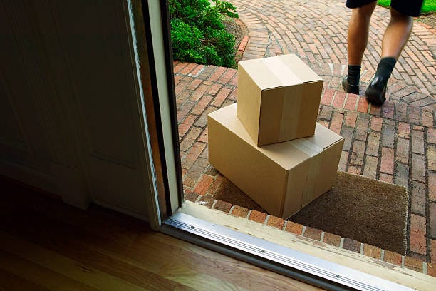 Delivery Two boxes being left on a door step by a courier.  package at door stock pictures, royalty-free photos & images