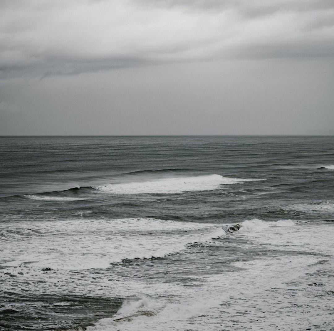 calm water at the sea during cloudy day