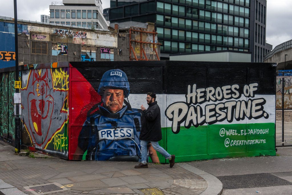 LONDON, ENGLAND - JANUARY 30: A man walks past graffiti titled 'Heroes of Palestine' featuring a picture of Palestinian journalist Wael Al-Dahdouh on January 30, 2024 in London, United Kingdom.