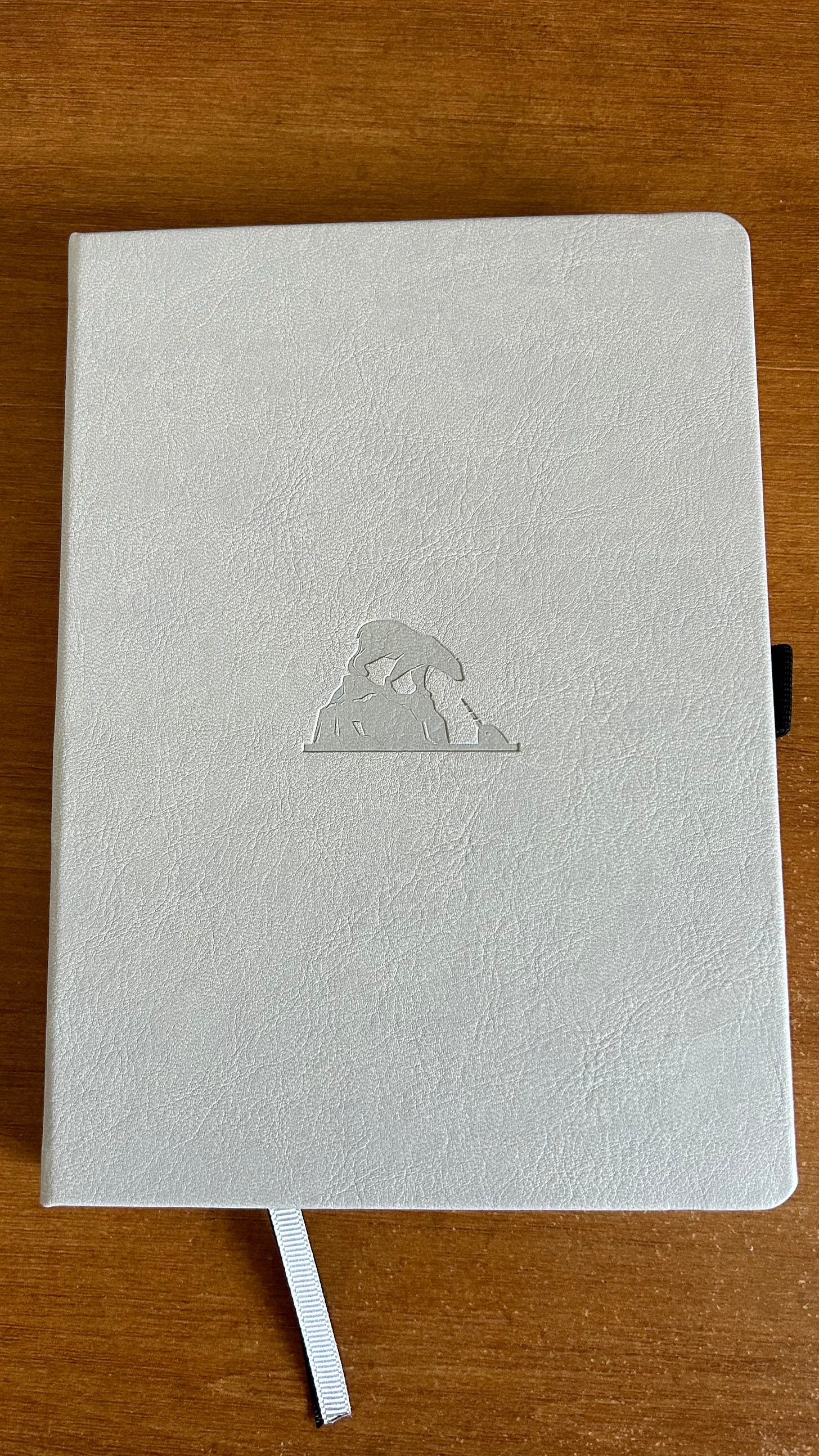 A grey Earth Collection A5+ Notebook with a polar bear image embossed on the front.
