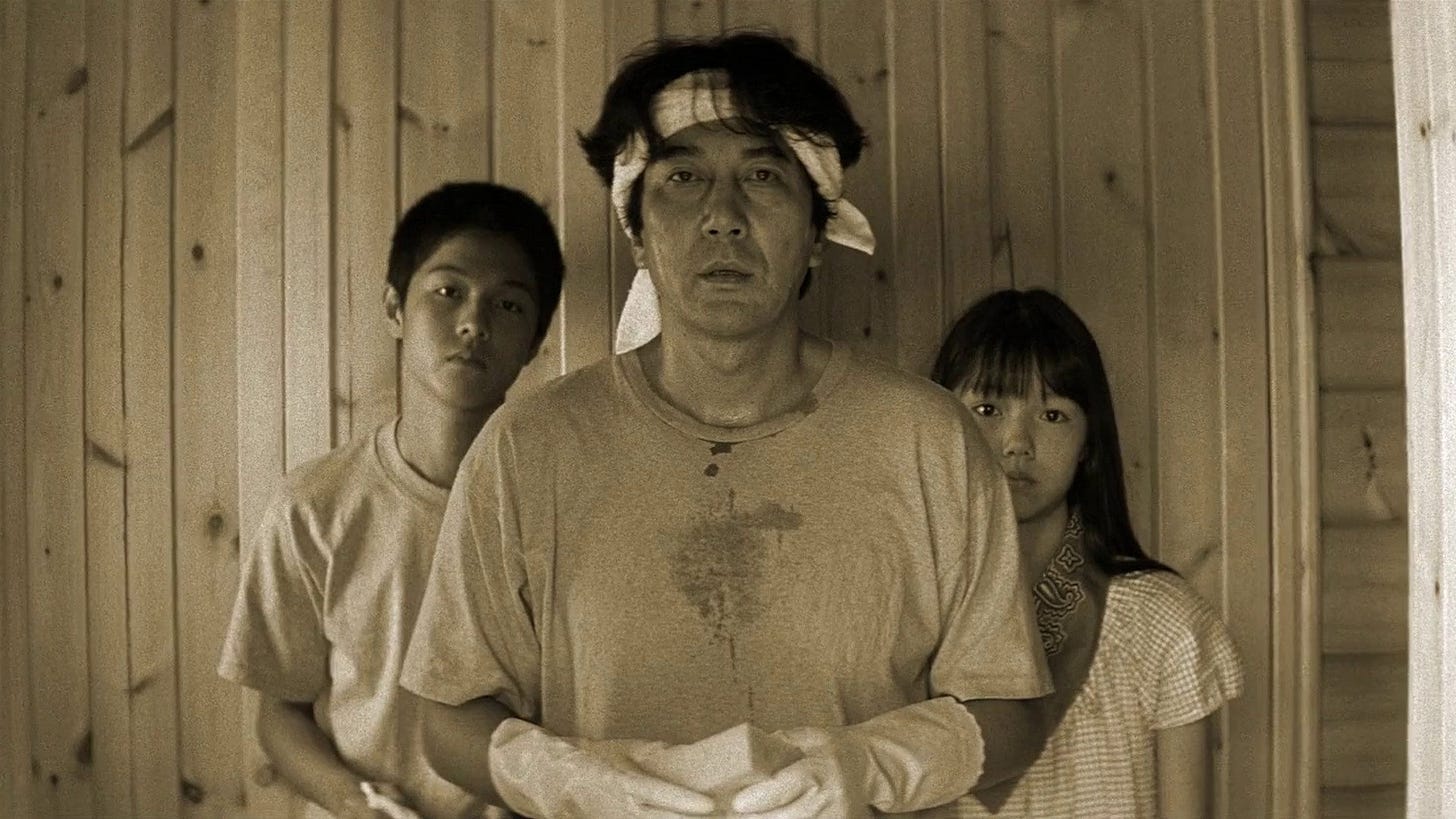 Eureka | Still features Koji Yakusho with a bandage on his head, observed by a younger boy and girl.