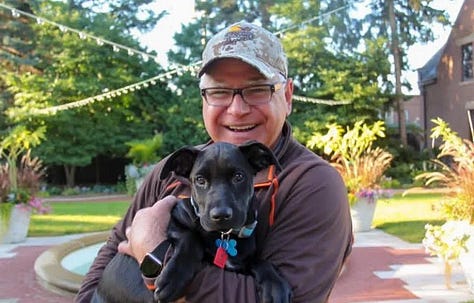 Tim Waltz and his black lab, Scout, Harris Walts signs, camo cap and banners, painted blue pumkin with ",la"