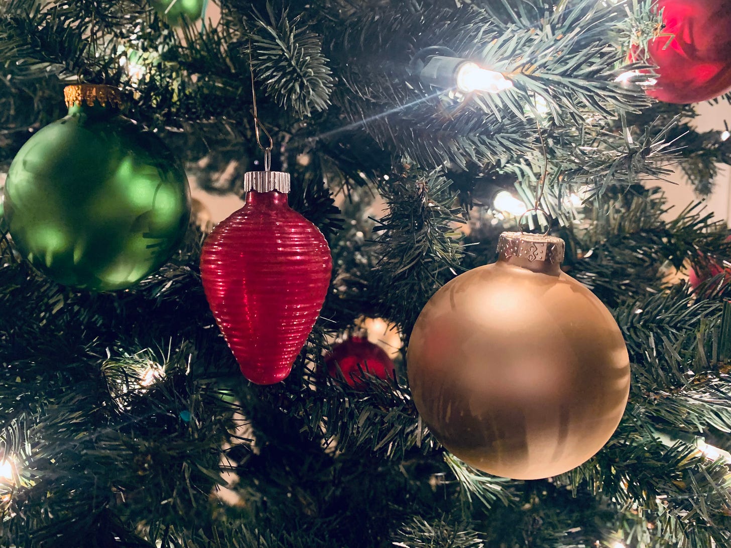 Image of ornaments and lights on a Christmas tree.