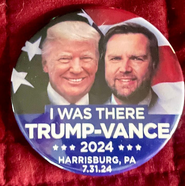 A photo of Mark & Kelly in front of their motorhome that matches ours, one with Tommy, Kelly & me playing games, my photo of Trump on stage at the Harrisburg rally and my commemorative button.
