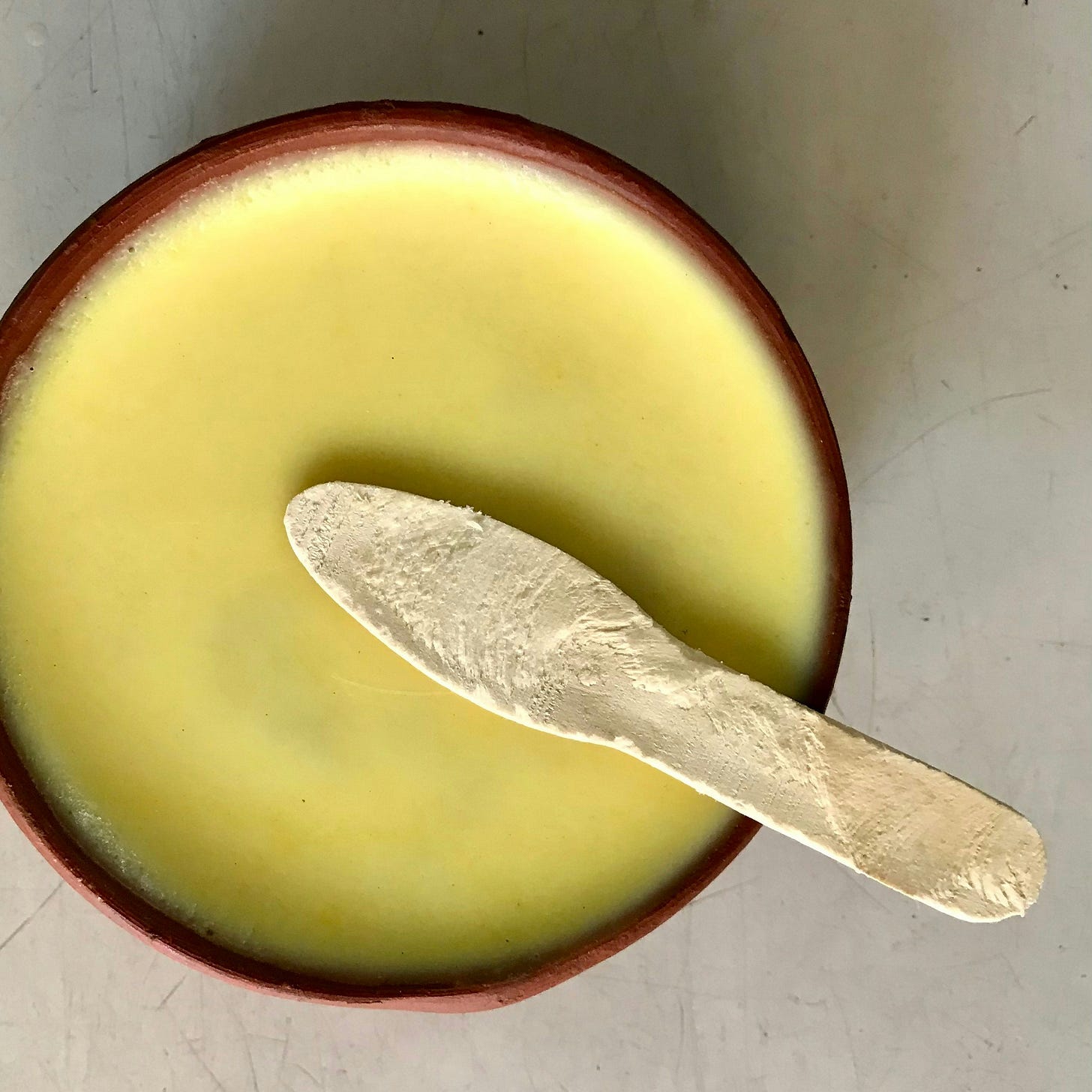 A bowl of pea soup with a wooden spoon