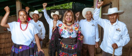 Six ouvriers agricoles posant en levant le poing, en signe de résistance