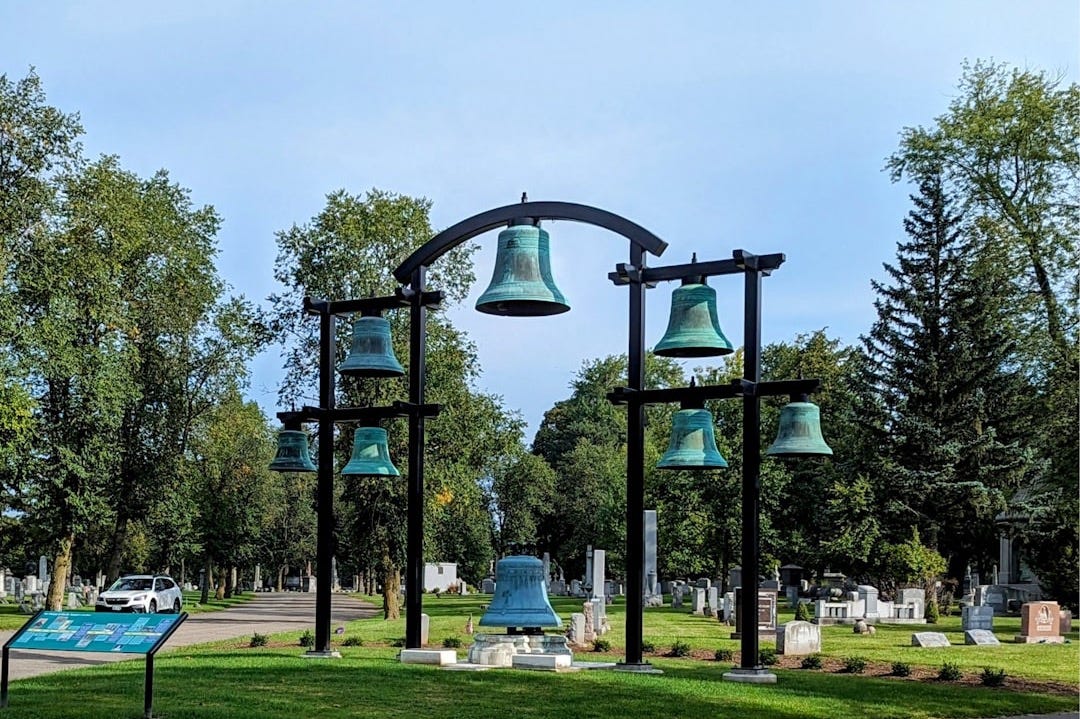 a group of bells sitting on top of a metal pole
