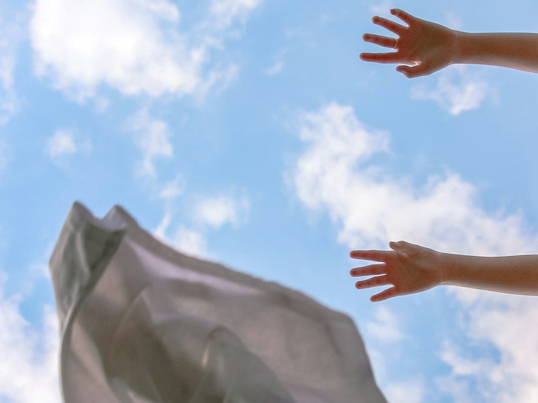 persons hand on white textile
