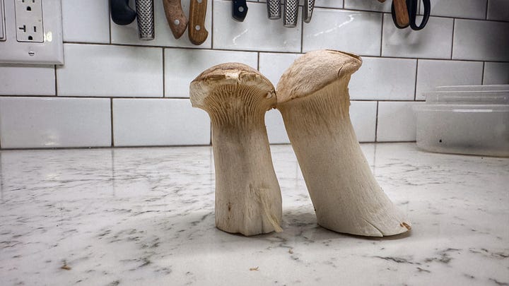 The first photo in the gallery shows a large bag of nori flakes on a counter beside a stout glass jar of whole hearts of palm. The second photo shows two king oyster mushrooms standing next to each other on a countertop.
