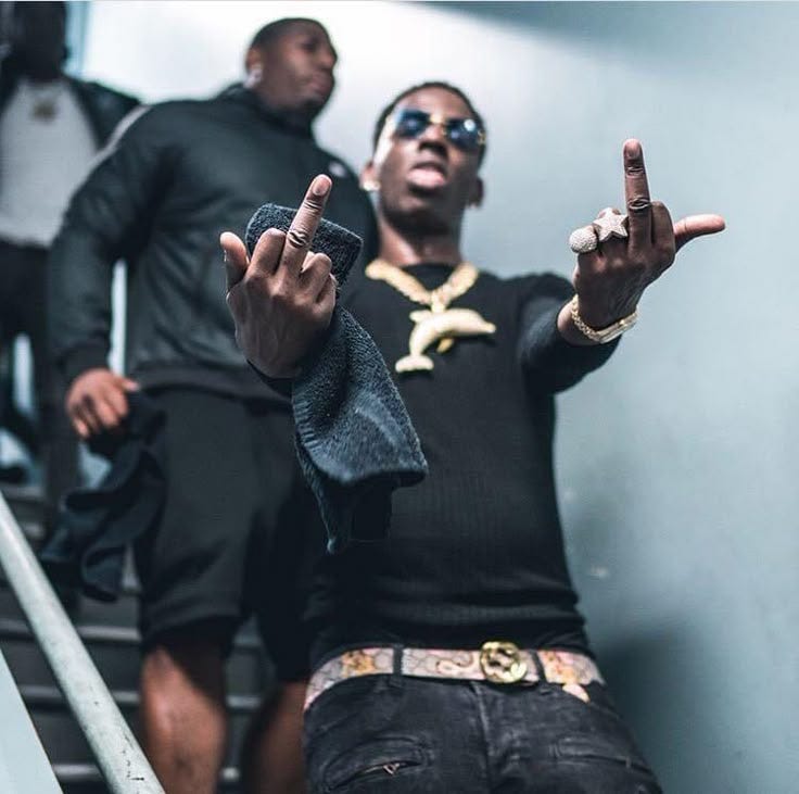 This may contain: a man sitting on top of a set of stairs with his hand in the air This may contain: a man sitting on top of a set of stairs with his hand in the air