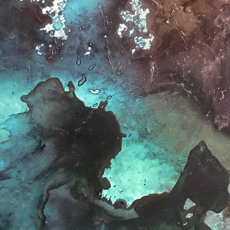 Some paintings as works in progress, with swirls of blue, green and silver.