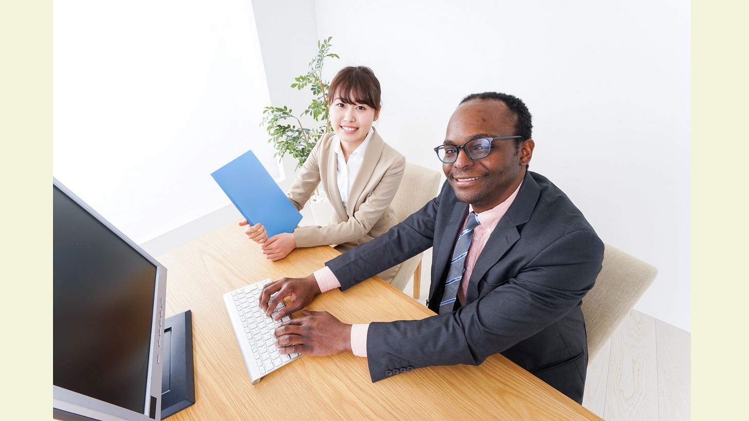 A Japanese person and a foreigner working in an office A Japanese person and a foreigner working in an office