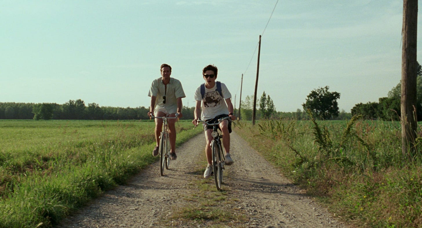 Two men riding bikes on a dirt road

Description automatically generated with medium confidence