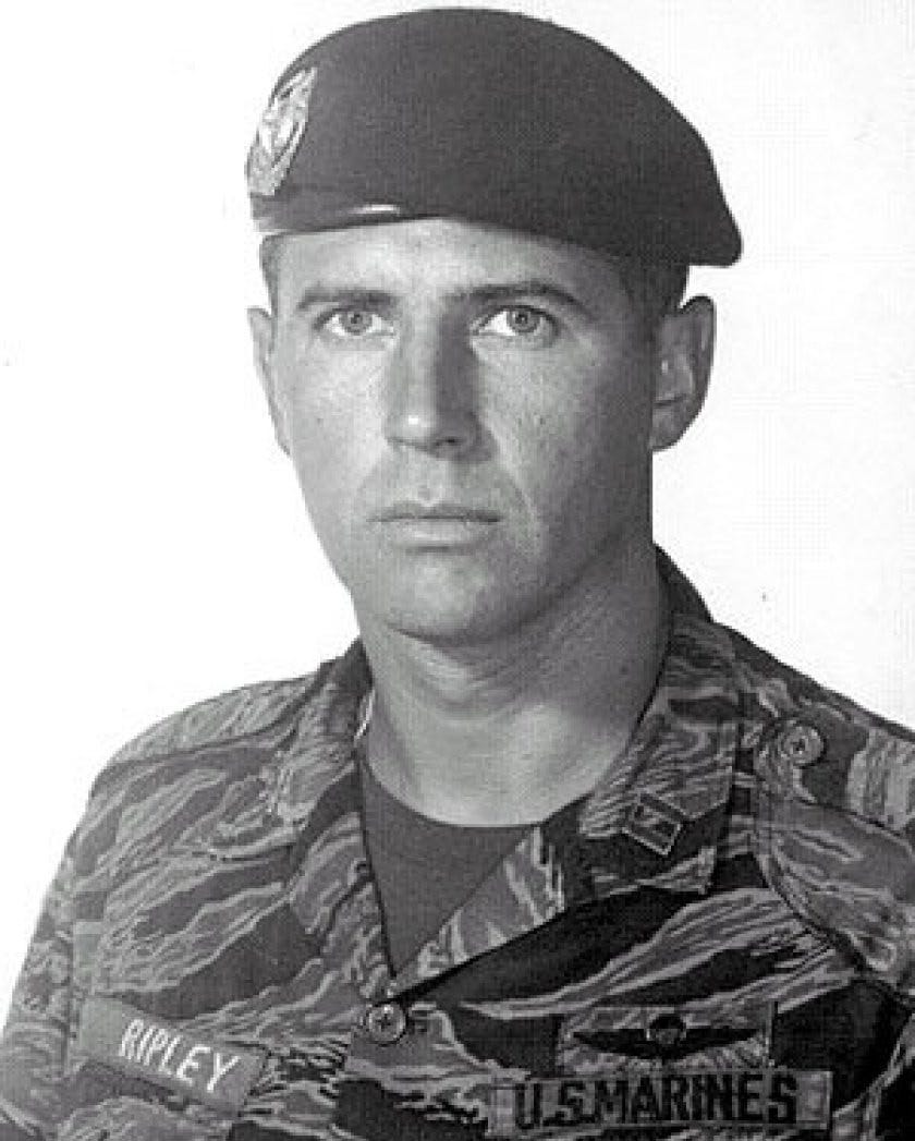 Black and white portrait of a young Marine officer in a beret and tiger-stripe camouflage with U.S. Marines and Ripley name tapes. Black and white portrait of a young Marine officer in a beret and tiger-stripe camouflage with U.S. Marines and Ripley name tapes.