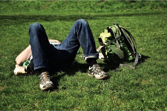 A person lying on their back on grass