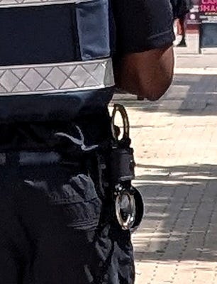 Close-up of rigid handcuffs in a quick-release holder on the belt of a Bristol BID Ranger, Broadmead, Bristol. The Almighty Gob, www.thealmightygob.com