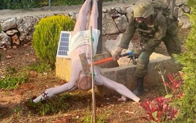 An IDF soldier appears to destroy a statue of Jesus in southern Lebanon, in an image uploaded to social media on April 19, 2026. (X/used in accordance with Clause 27a of the Copyright Law)