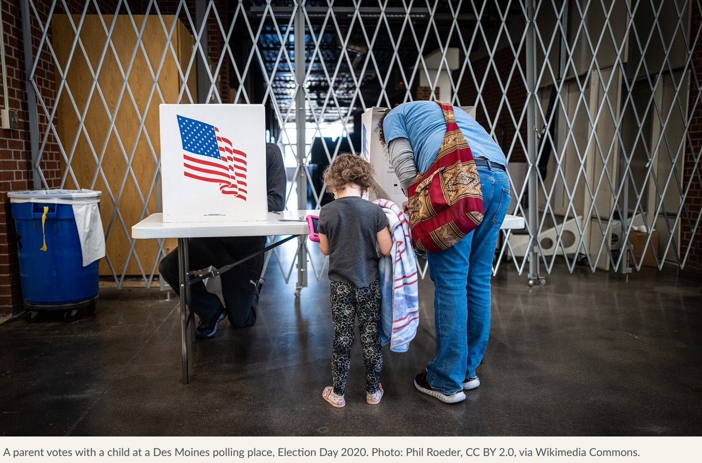 A parent votes with a child at a Des Moines polling place, Election Day 2020. Photo: Phil Roeder, CC BY 2.0, via Wikimedia Commons. A parent votes with a child at a Des Moines polling place, Election Day 2020. Photo: Phil Roeder, CC BY 2.0, via Wikimedia Commons.
