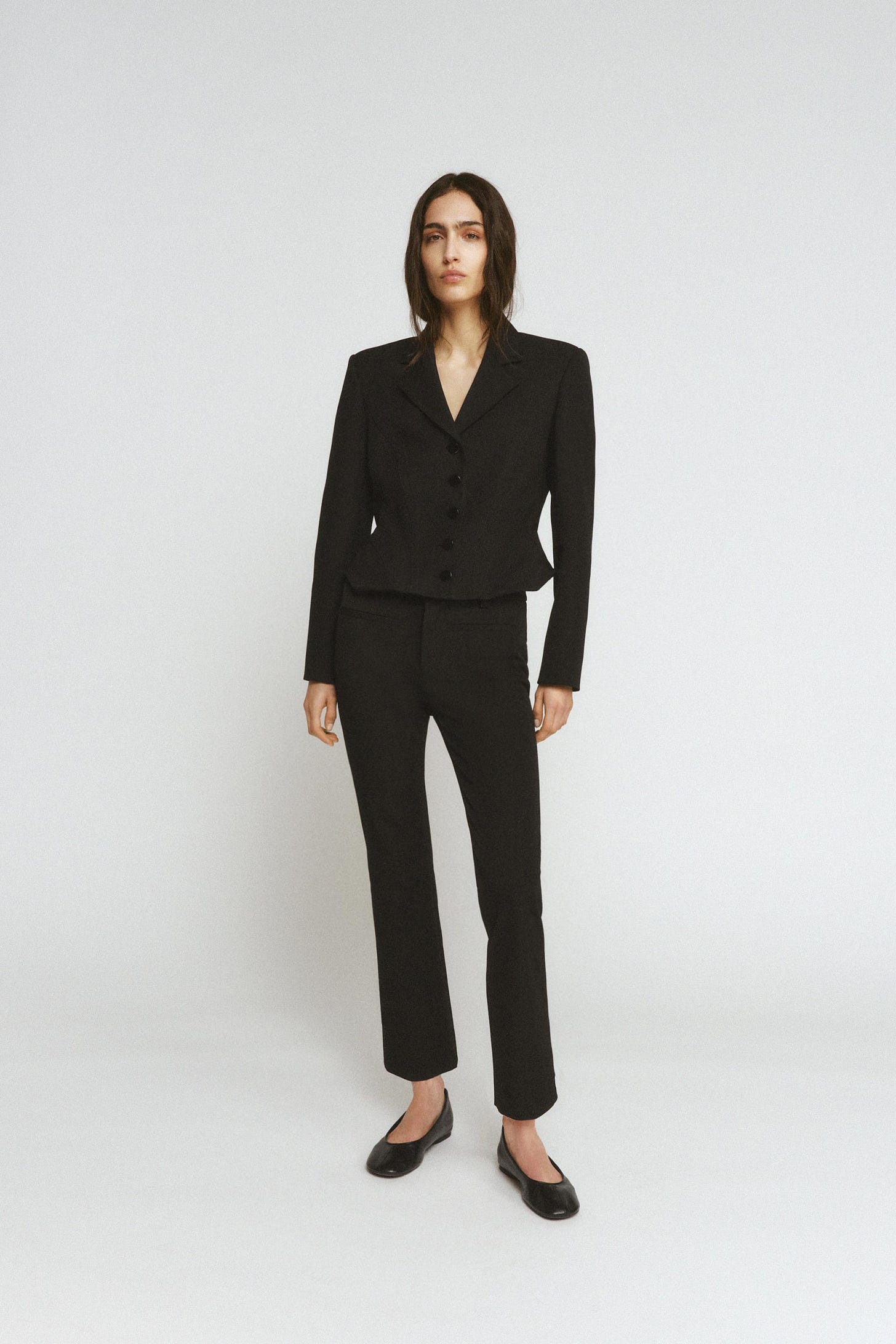 Black suit set with a button-up jacket and straight trousers.