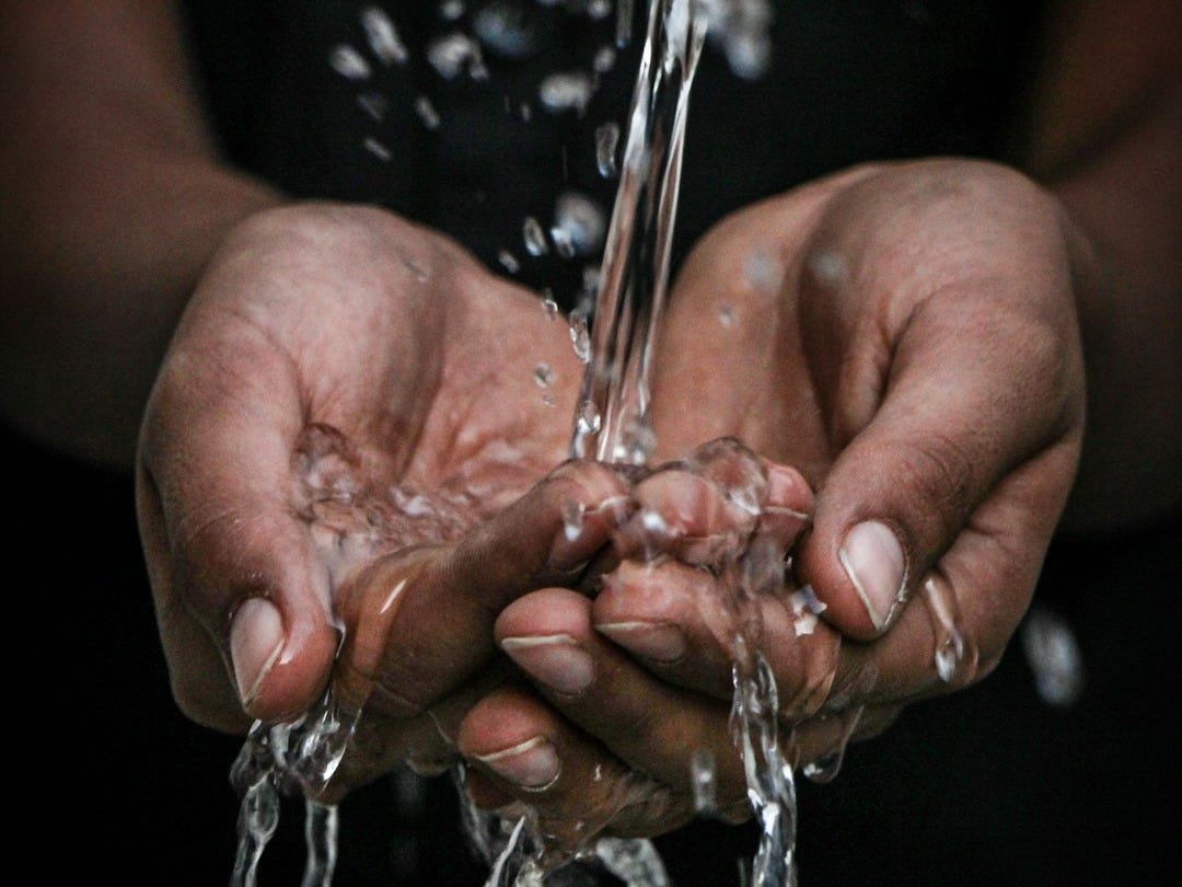 pouring water on person's hands pouring water on person's hands