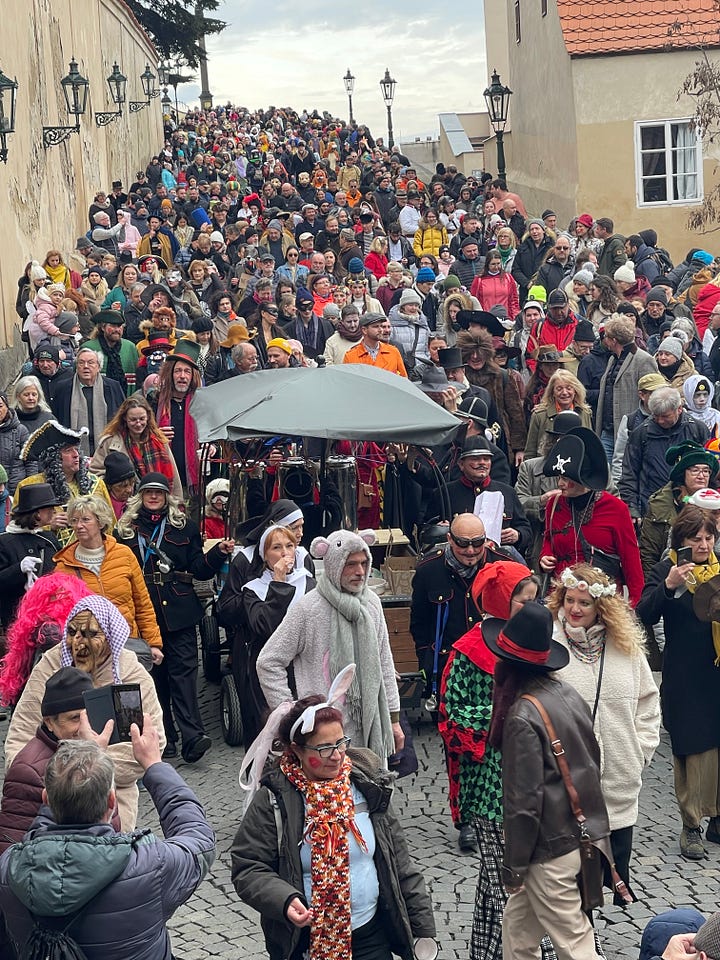 Masopust celebrants in traditional masks and costumes parading through the streets of Prague.