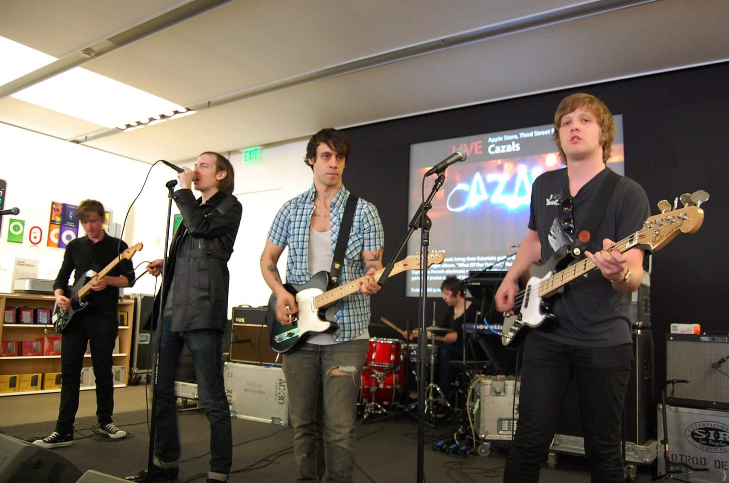 A photo taken from the Theater seats at Apple Third Street Promenade. The members of the band Cazals are singing and playing guitar. A photo taken from the Theater seats at Apple Third Street Promenade. The members of the band Cazals are singing and playing guitar.