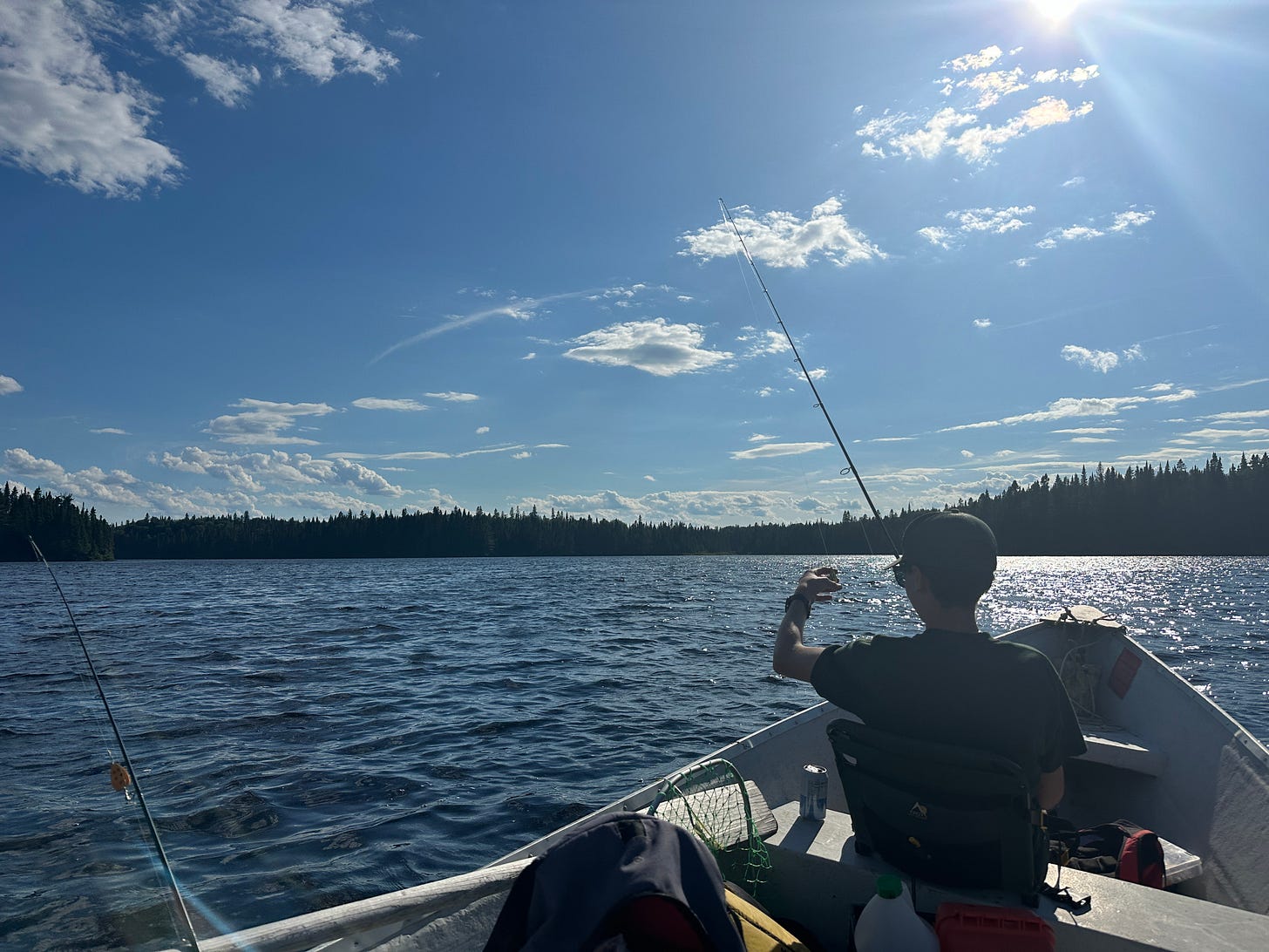 Fisherman getting a fishing line ready to cast while sitting on a boat in a lake. Fisherman getting a fishing line ready to cast while sitting on a boat in a lake.