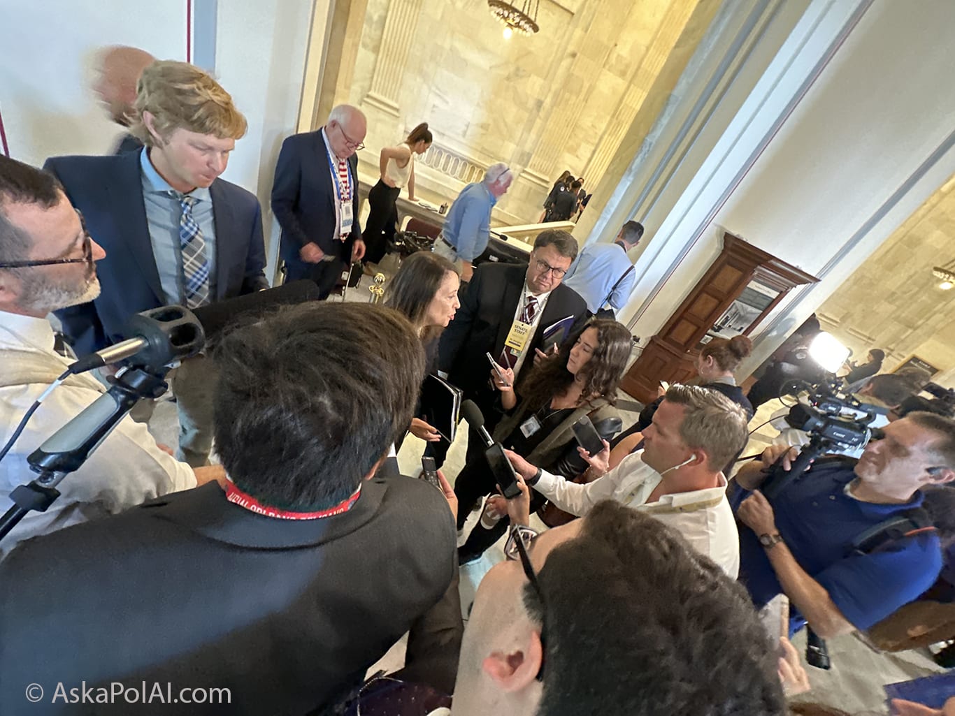 A US Senator answers questions from reporters encircling her © Ask a Pol AI 