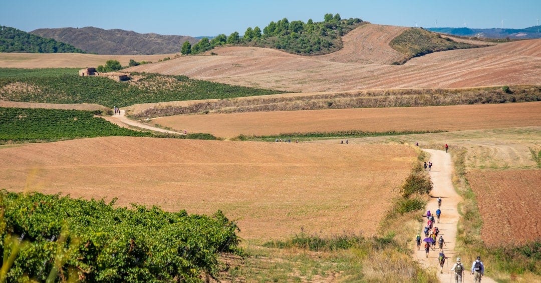 a group of people riding bikes down a dirt road a group of people riding bikes down a dirt road