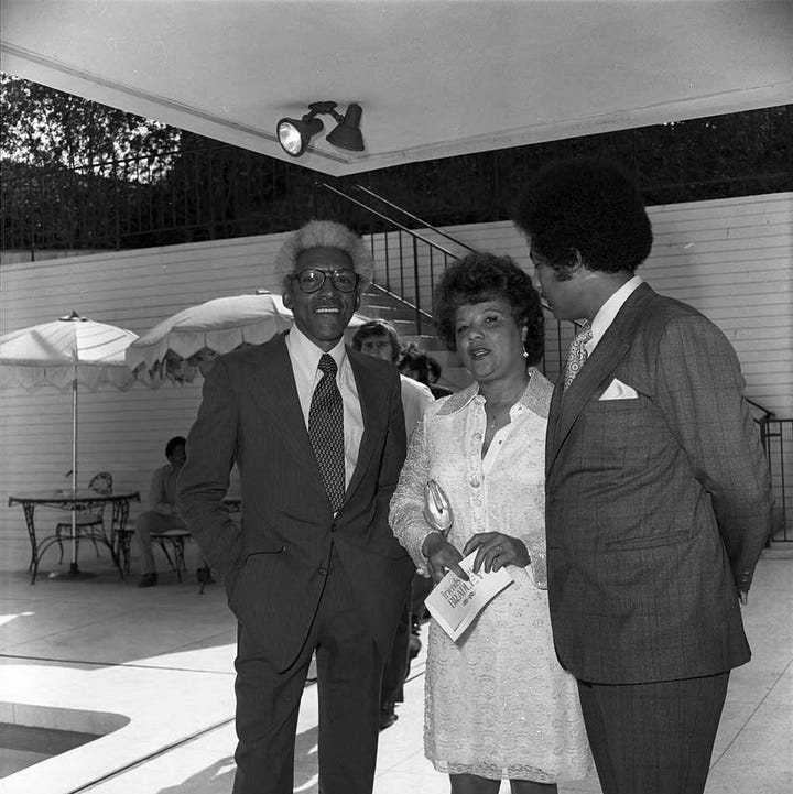 Left to right: Bayard Rustin (4th from left) poses with Los Angeles Chapter A. Philip Randolph Institute President Samuel McNeal, Jr. (left), LA County AFL-CIO Executive Secretary Sigmund Arywitz (3rd from left), Tom Bradley (5th from left), A. Philip Randal Institute Field Director Lois Felder (2nd from right), Arnett Hartsfield (right) and others during an event to honor Mr. Rustin at the home of singer Ray Charles, Los Angeles, 1973; Bayard Rustin talking with Tom Bradley, Los Angeles, 1973; Bayard Rustin standing between Sigmund Arywitz and Samuel McNeal, Jr., Los Angeles, 1973; Bayard Rustin, Gwen Green, and Ken Orduna standing together, Los Angeles, 1973. All photos by Guy Crowder ©Tom and Ethel Bradley Center