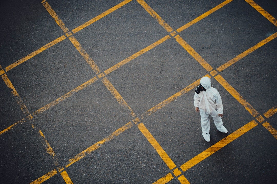 man in white thobe walking on grey and yellow concrete pavement man in white thobe walking on grey and yellow concrete pavement