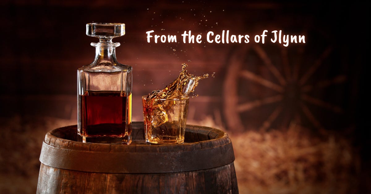 Whiskey in a decanter and whiskey splashing from a glass - both sitting atop a whiskey barrel in a low-lit barn