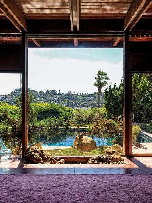 A view from the living room, over the indoor rock garden, out to the pool. Silver Lake Reservoir is beyond the hedges.