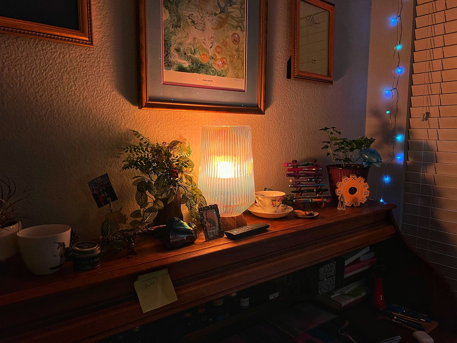 the top of a rolltop desk cluttered with pens and plants