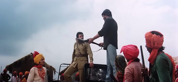 snapshot from the movie Rajput where the rebel dacoits are seen surrendering their guns to the police