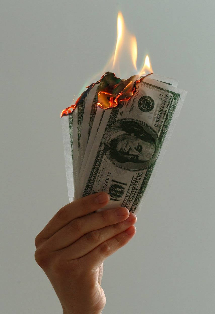 time lapse photography of several burning US dollar banknotes