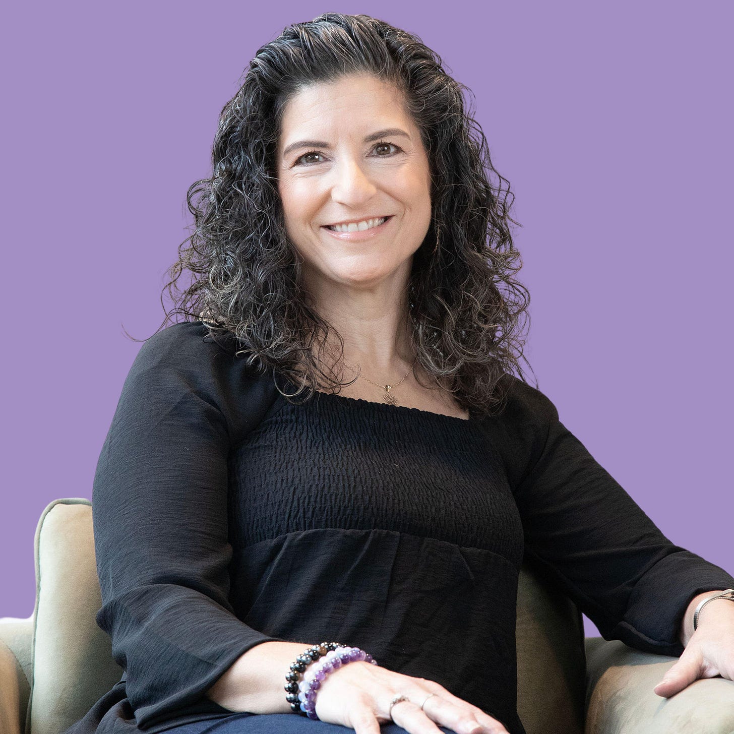 woman sitting with purple background